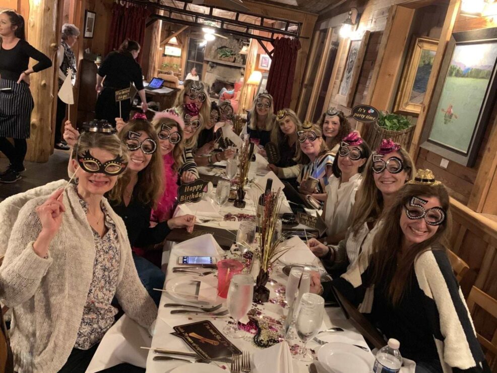 ladies in funny glasses at a birthday party at the bar