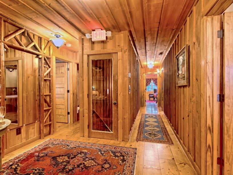main hallway featuring wood walls, ceiling and floor