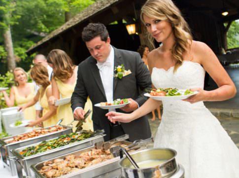 bride, groom and bridal party serving their plates from buffet