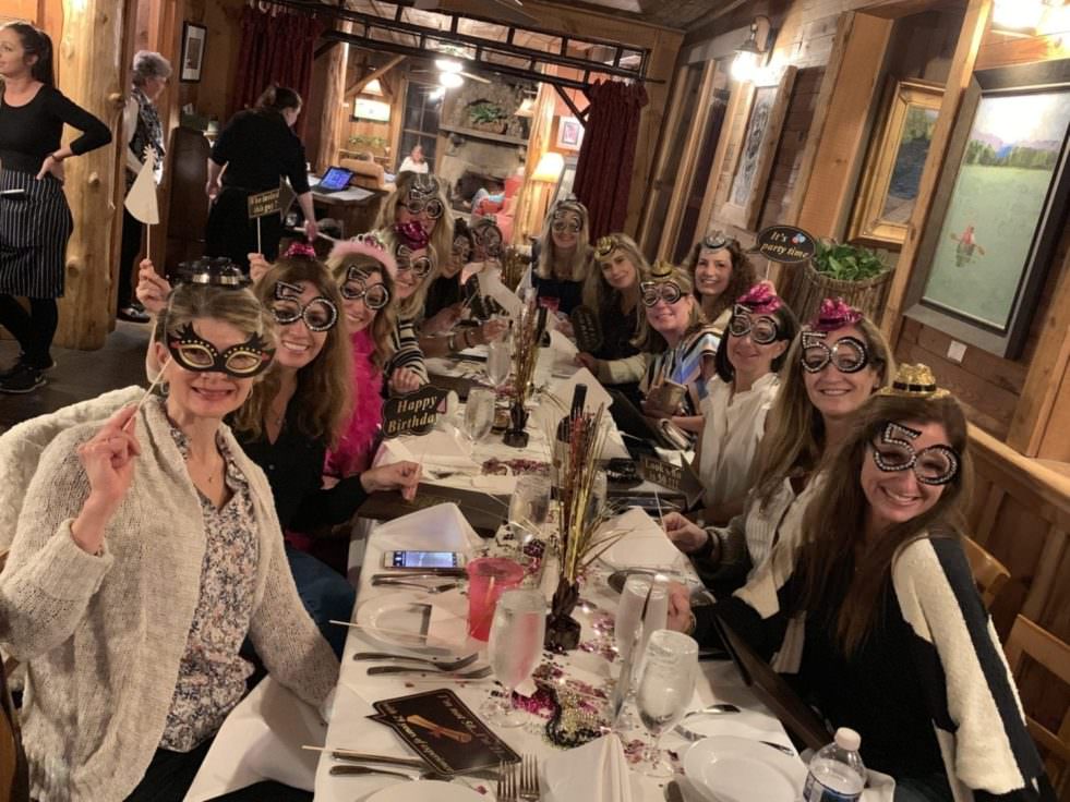 ladies in funny glasses at a birthday party at the bar