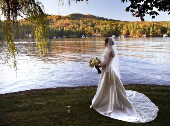bride standing on shore looking out over lake